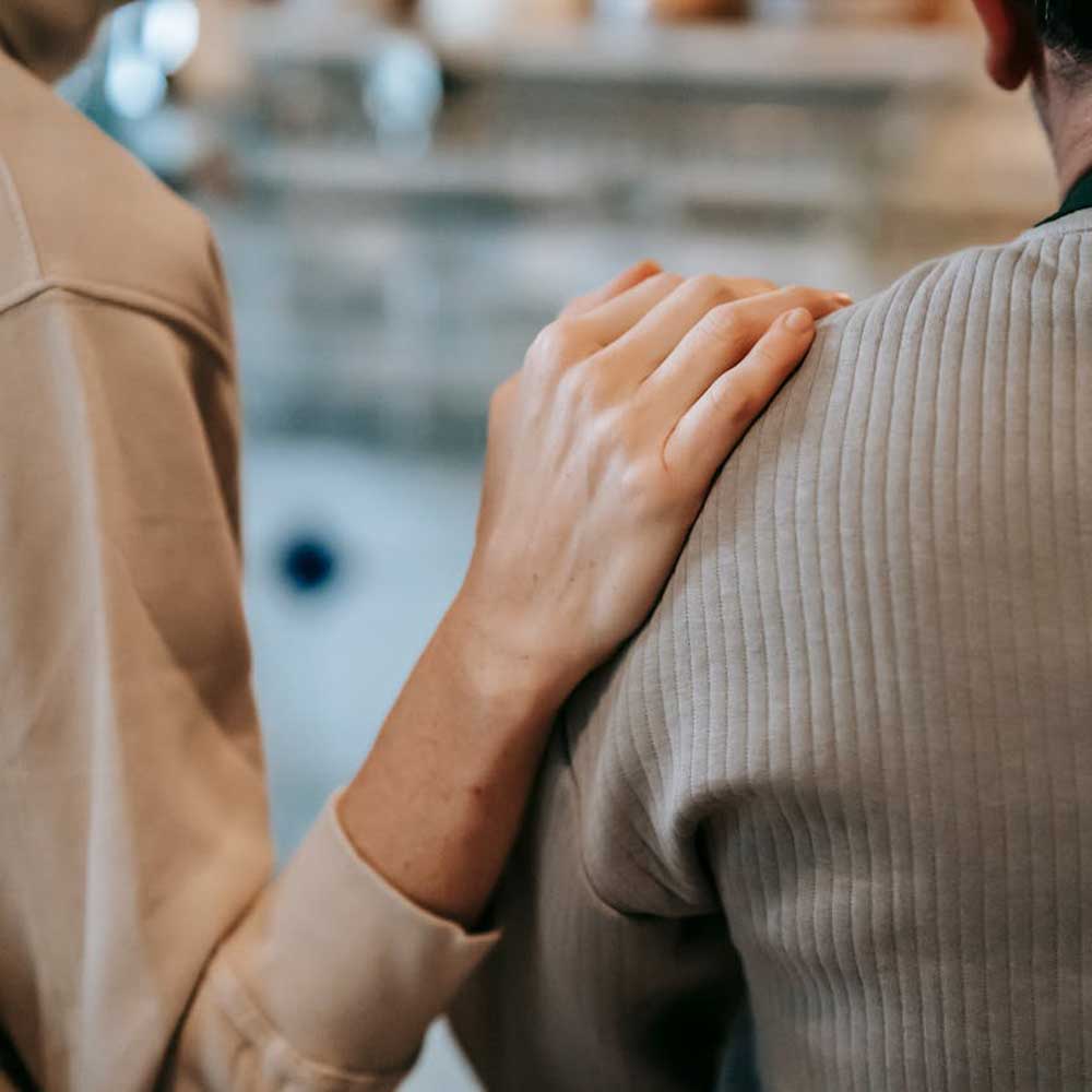 Two female counsellors speaking with a male client